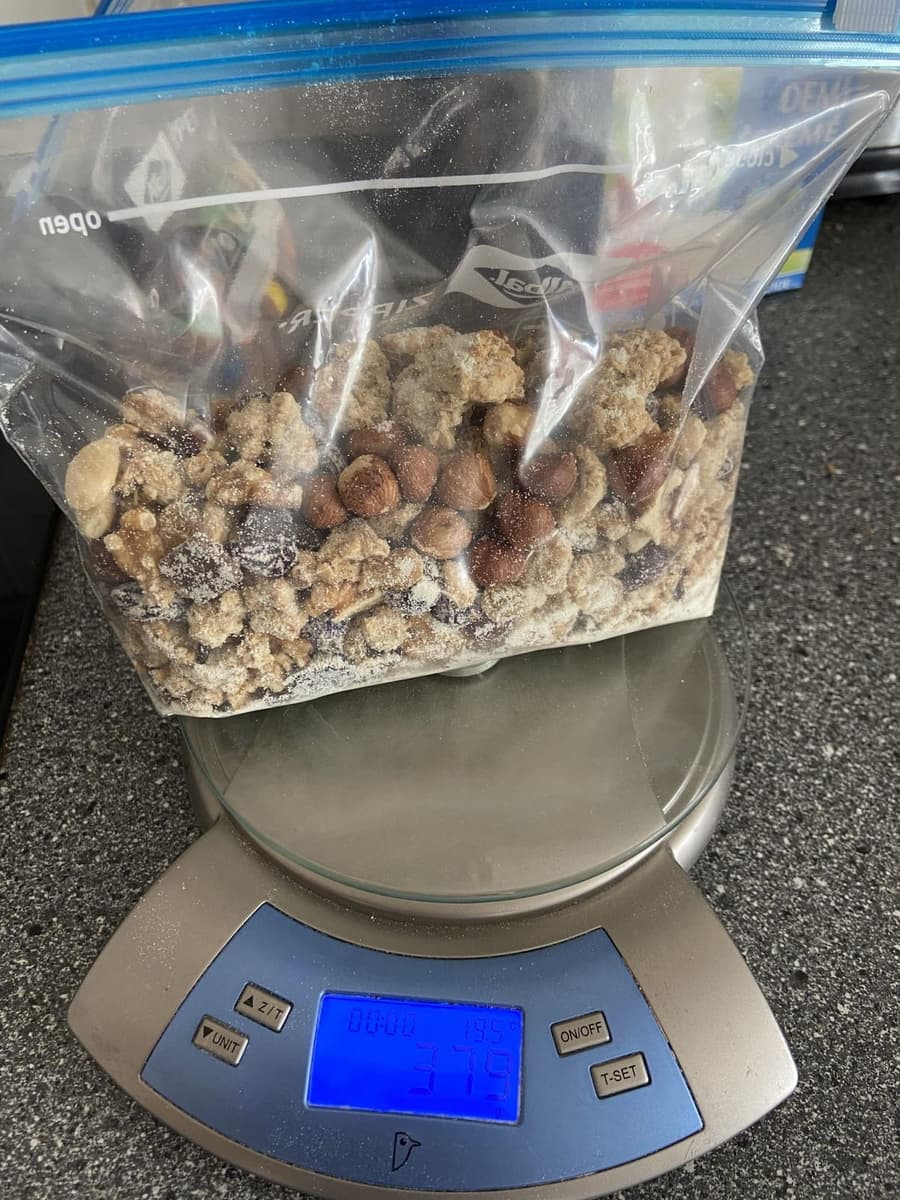 Muesli et fruits secs dans un sachet zip pesés sur une balance de cuisine avant un trek